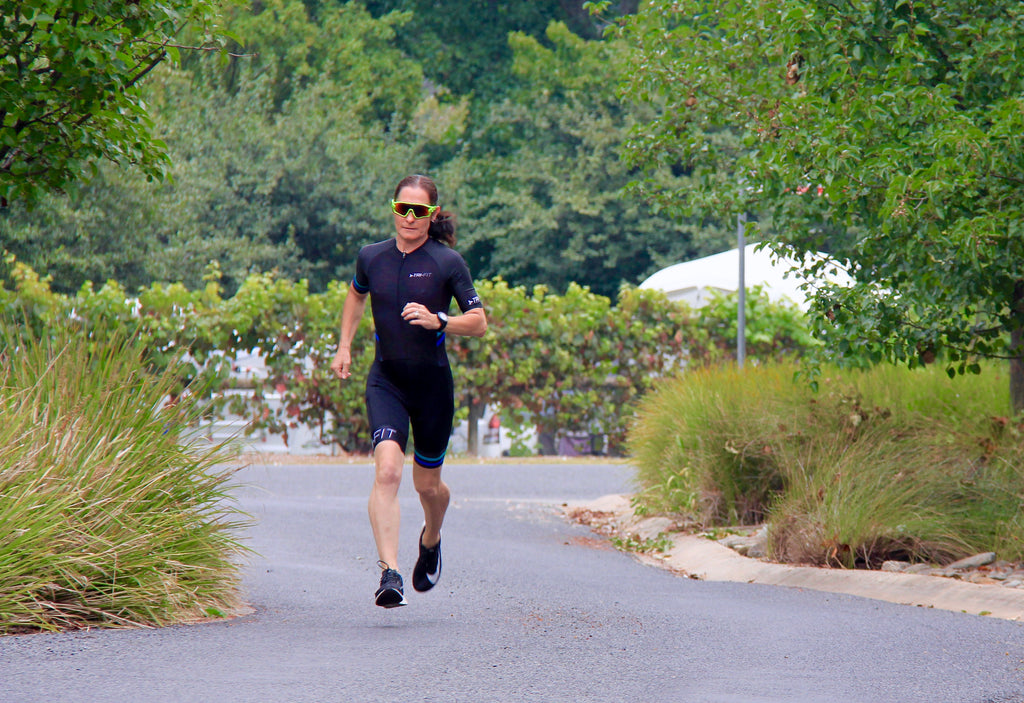 Woman running in the EVO women's tri suit amongst greenery