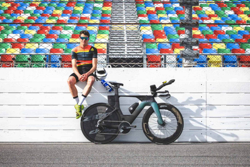 cyclist sat on a wall next to his bike on a race track