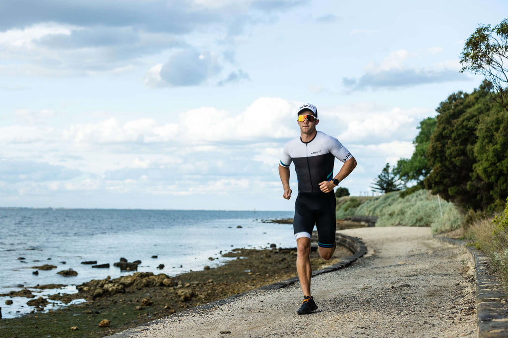 Man running whilst wearing performance snapback and EVO mens tri suit